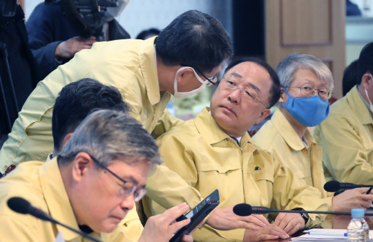 홍남기(오른쪽 두번째) 부총리 겸 기획재정부 장관과 은성수(오른쪽 세번째) 금융위원장이 15일 정부서울청사에서 열린 긴급경제상황점검회의 직전에 대화하고 있다.  연합뉴스